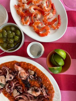 Vibrant seafood platter featuring shrimp, octopus, and olives, perfect for a summer feast.