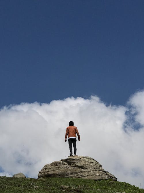 Free Person Standing  On A Rock Under Blue Sky Stock Photo
