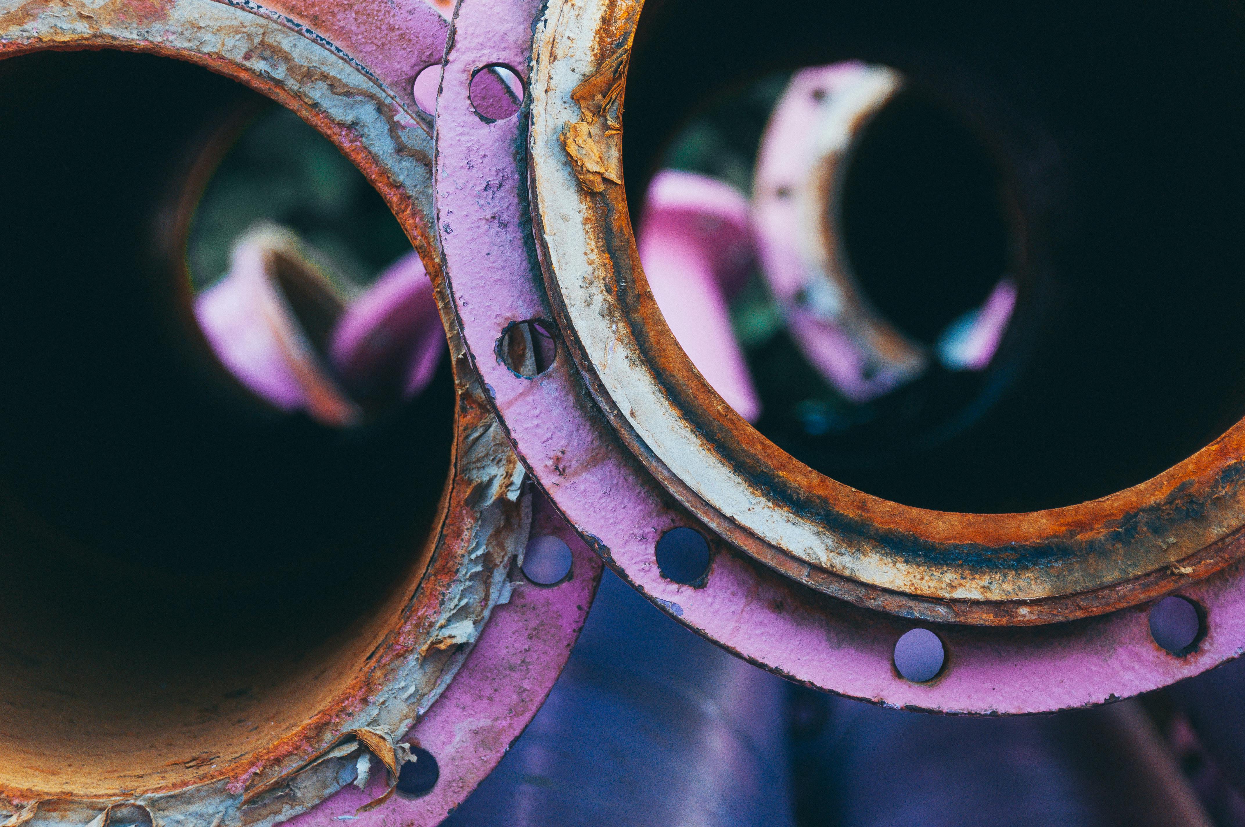 Gratis Detaljeret visning af rustne, lilla-farvede industrirør, der fremviser tekstur og forfald. Lagerfoto