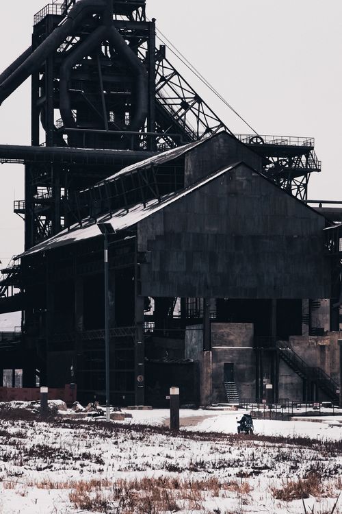 Free A snow-covered abandoned factory with industrial structures during winter. Stock Photo