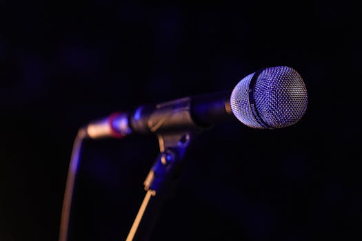 Close-up of a microphone set up on stage, highlighting concert ambiance.