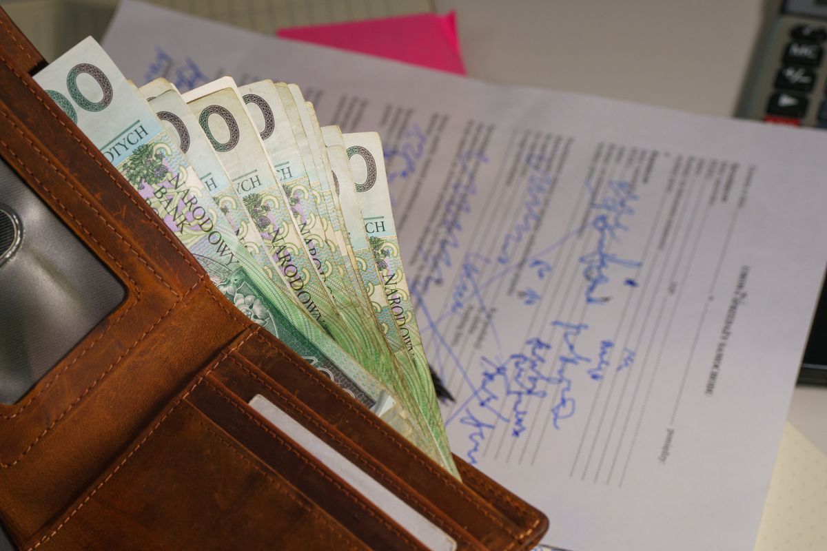 The penalty ladder for telemarketing breaches Wallet holding cash beside a signed document