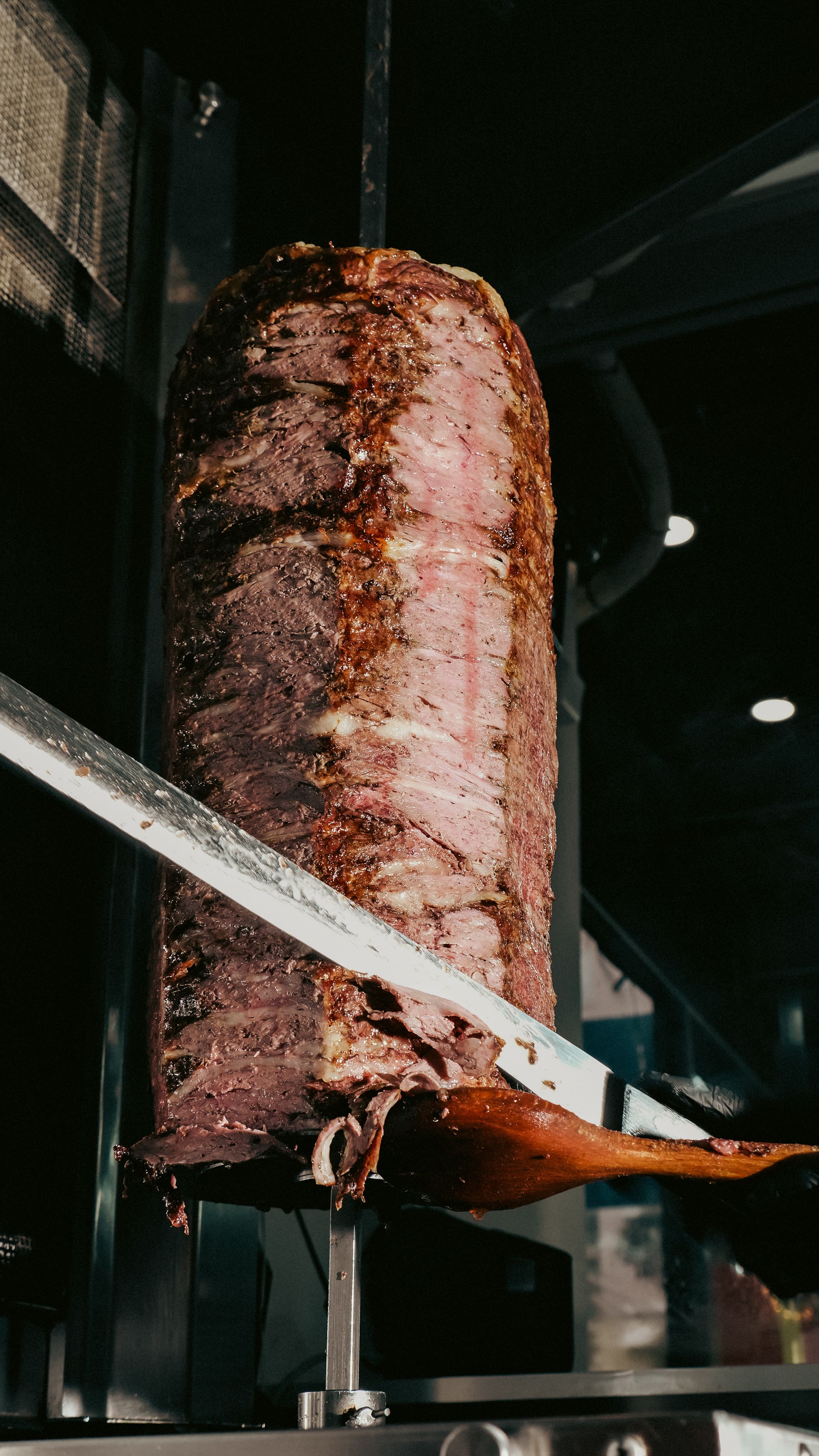 Döner wird mit dem Messer vom Spieß geschnitten