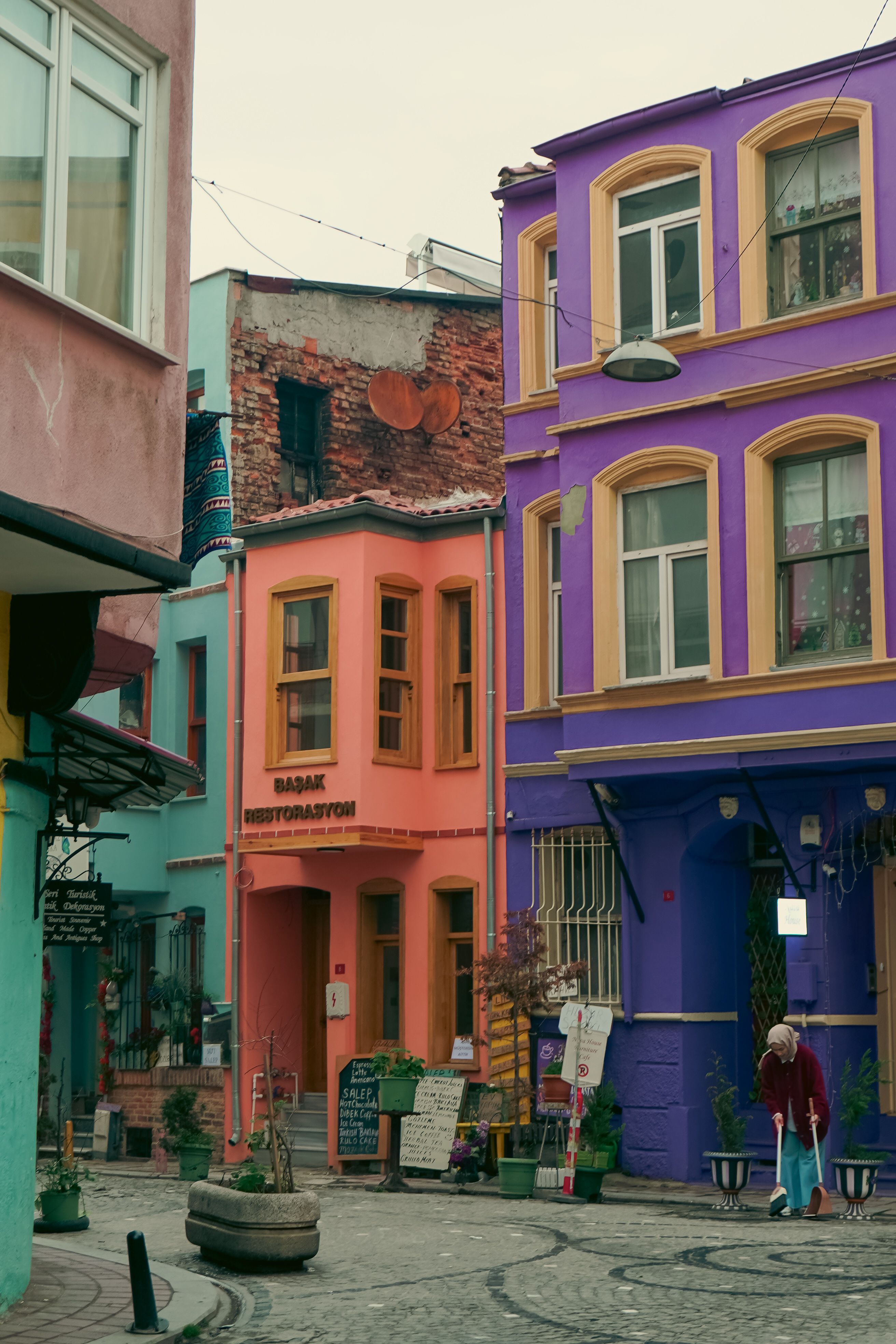 Fotomural Encantadores edificios coloridos en una vibrante esquina de una calle residencial urbana, que exhiben tonos vivos.