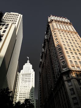 Close-up low angle shot of modern skyscrapers with unique architecture under a dramatic sky.