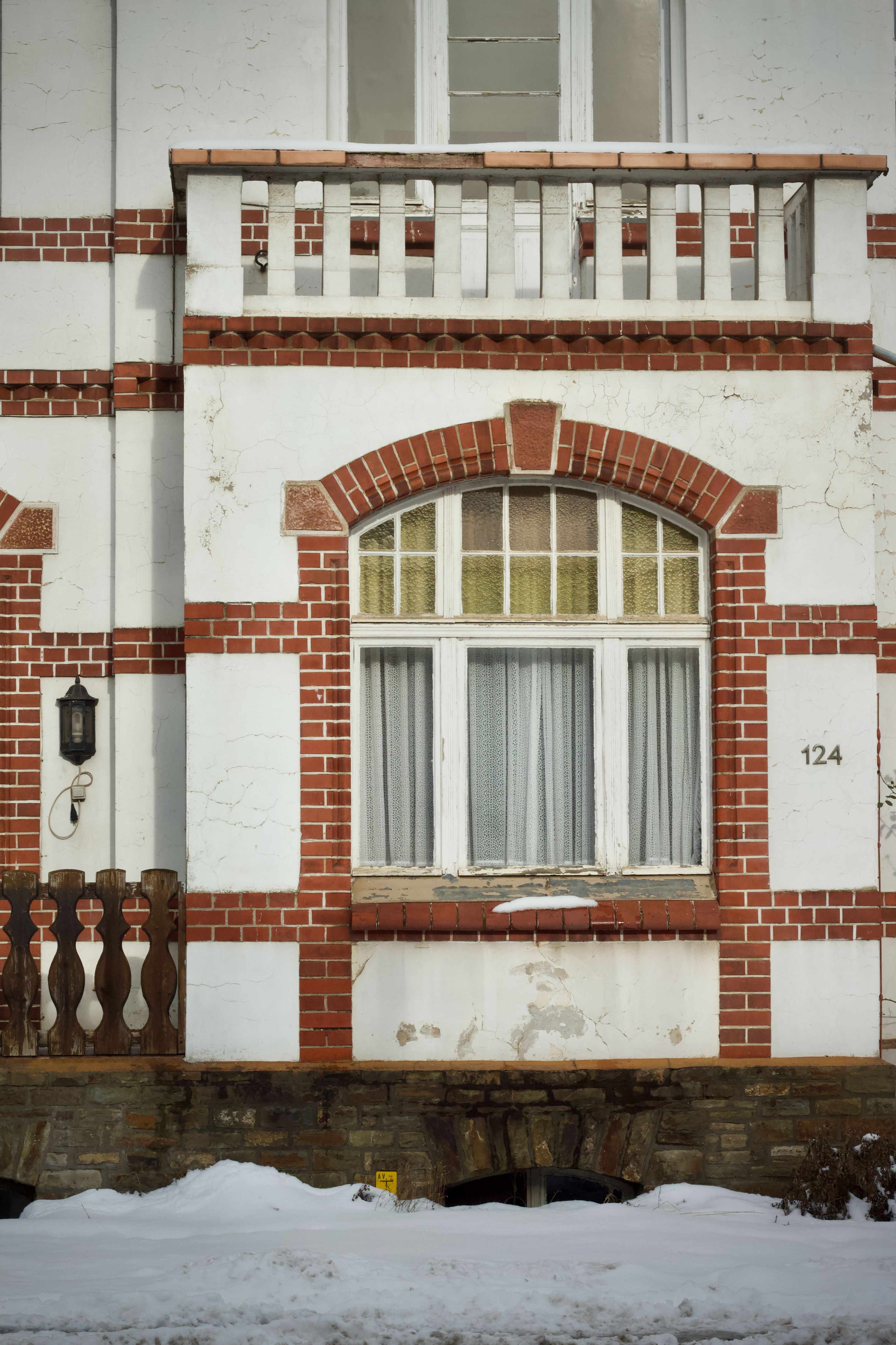 grátis Fachada de casa de tijolos antiga com janela e neve em cenário de inverno. Foto profissional