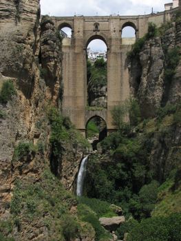 A breathtaking view of the Puente Nuevo bridge in Ronda, Spain, with cascading waterfall.
