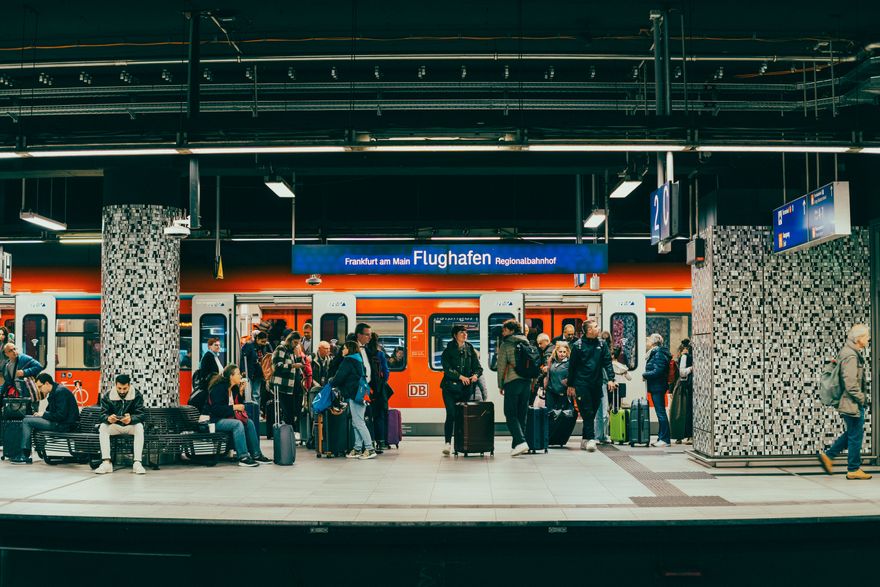 Peron de tren la aeroportul din Frankfurt cu pasageri care așteaptă
