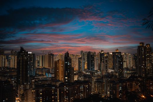 Stunning view of Hong Kong's cityscape at twilight, featuring illuminated skyscrapers and dramatic evening clouds.
