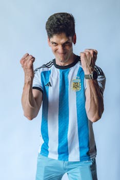 A passionate fan celebrates wearing an Argentina soccer jersey indoors.
