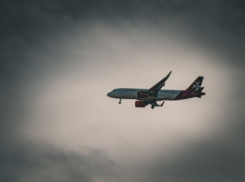 Free Commercial jet silhouetted against a moody, overcast sky, symbolizing exploration and freedom in air travel. Stock Photo