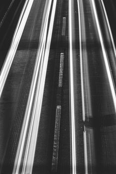 Captivating long exposure shot of highway lights in monochrome, creating streaks of motion.