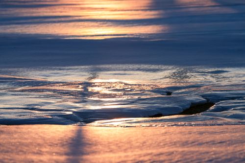 Free Glistening icy surface reflecting sunset hues, creating a serene winter landscape. Stock Photo