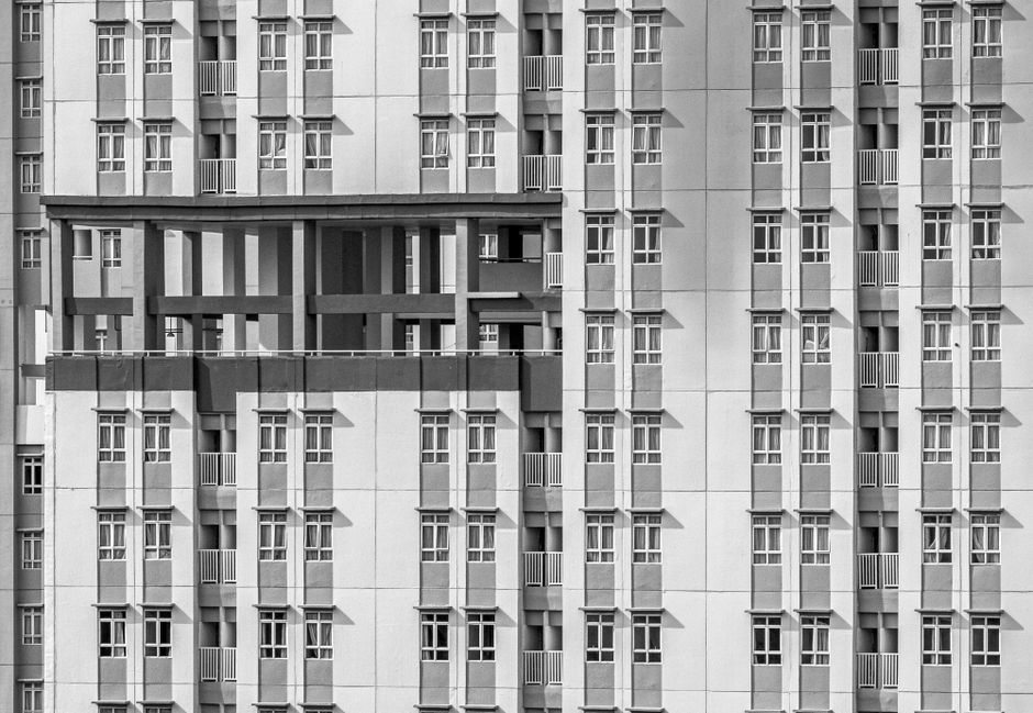 Black and white geometric abstract of a high-rise building facade showcasing modern architecture.