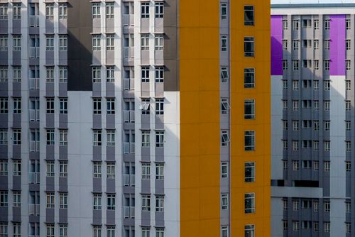 Free Vibrant facade of a modern apartment building with colorful geometric patterns and shadow play. Stock Photo
