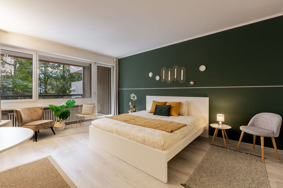 Modulare Pflanzenwand im hellen Wohnzimmer mit integrierter Beleuchtung und Sitzecke