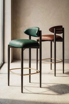 Stylish green and brown bar stools in a sunlit minimalist interior.