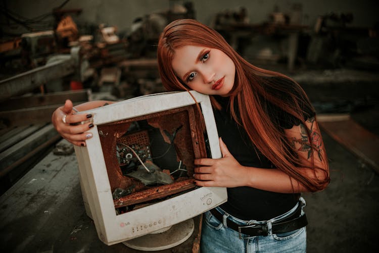 Woman In Black Shirt Holding A White Broken Monitor