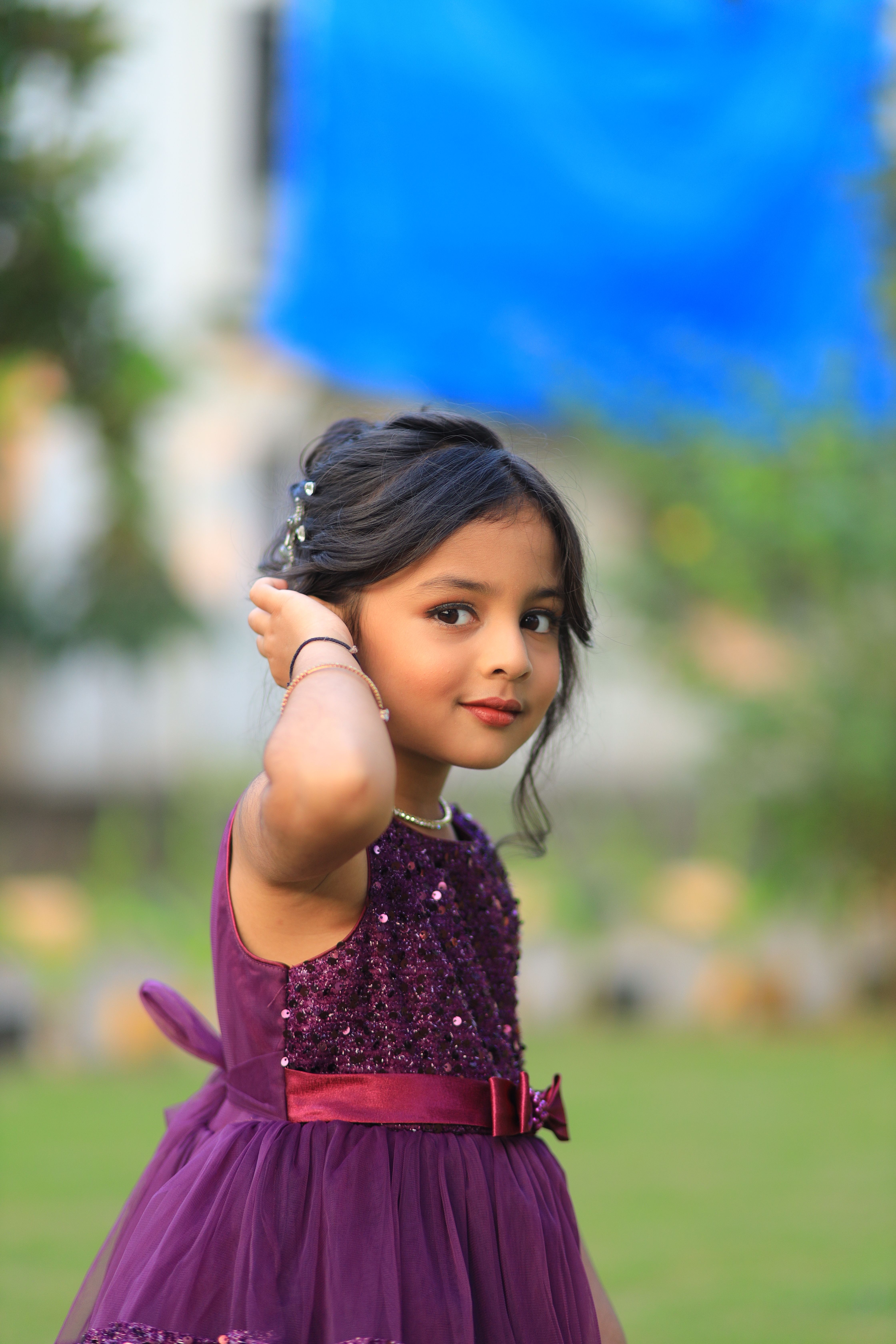 A young girl in a stylish purple dress enjoying an outdoor event, captured beautifully.