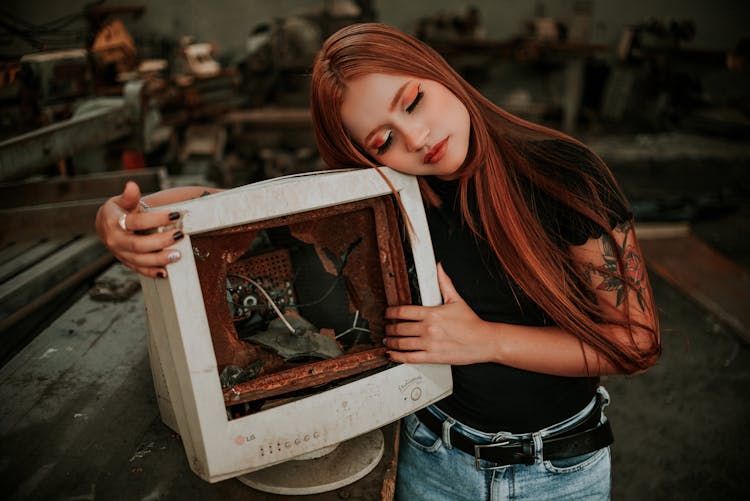 Woman In Black Shirt Holding Broken Monitor