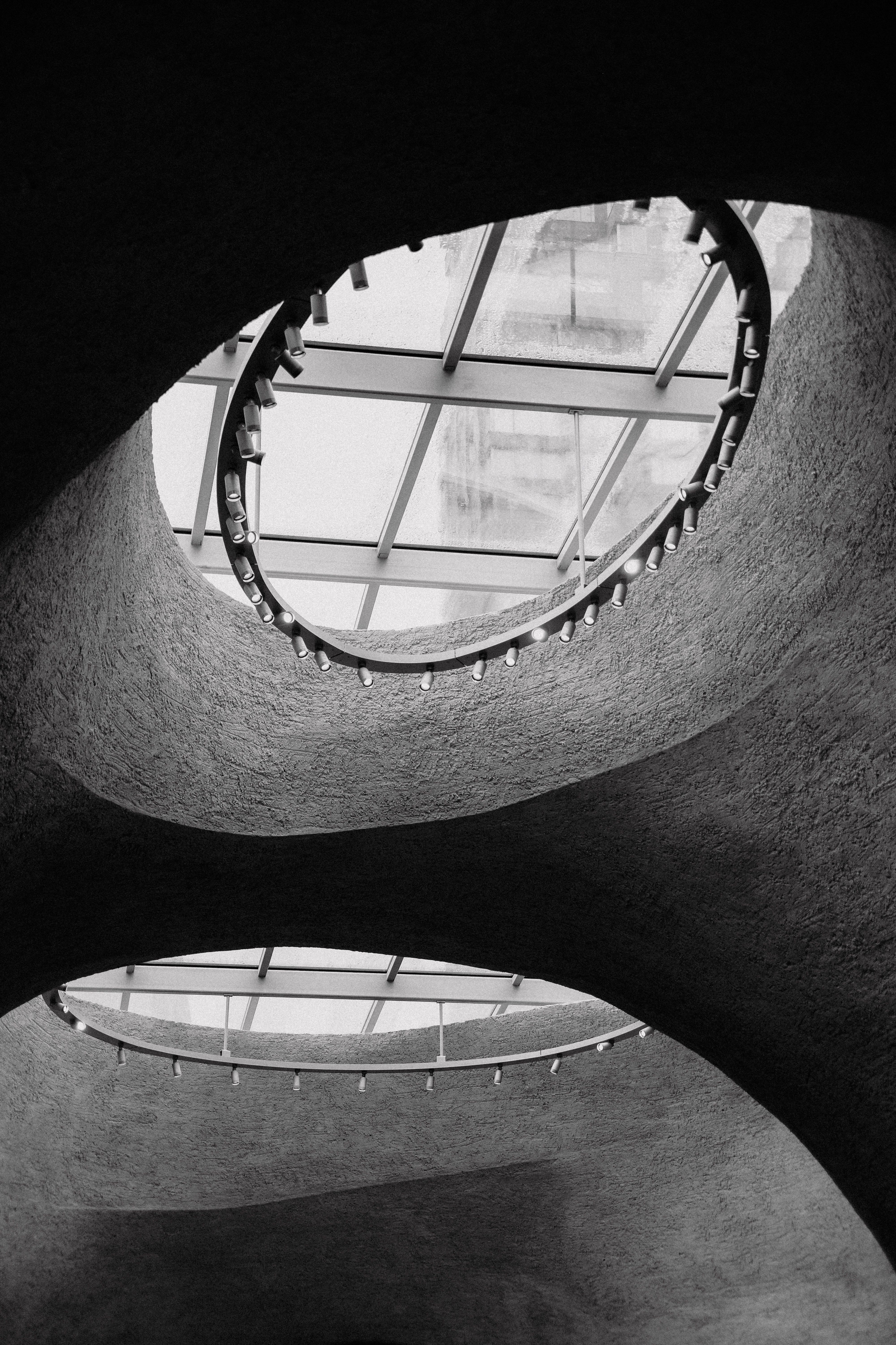 Black and white shot of a modern ceiling with circular skylights.