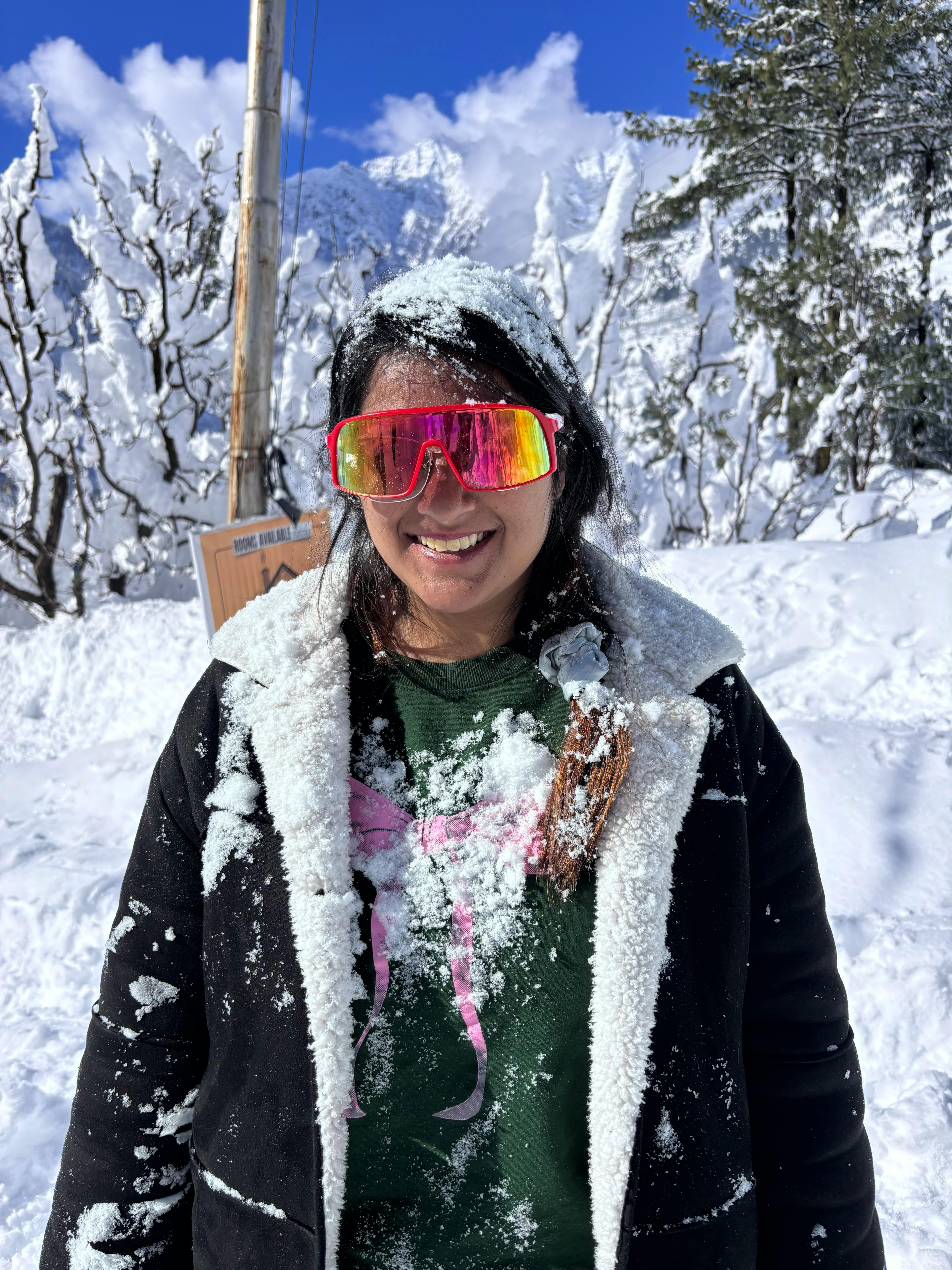 Woman enjoys snow-filled winter adventure in scenic Manali, India.