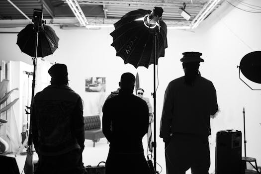 Three people in silhouette during a creative photoshoot session in a studio environment.