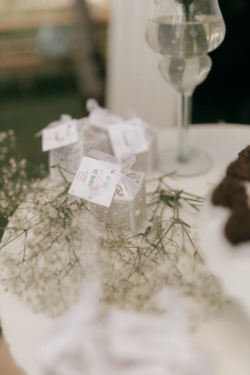 Free Table with wedding favors, baby's breath, and glass candle holder. Soft and elegant setting. Stock Photo