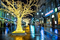 夜晚的城市街道充满活力，点缀着耀眼的灯光和树木，营造出节日的氛围