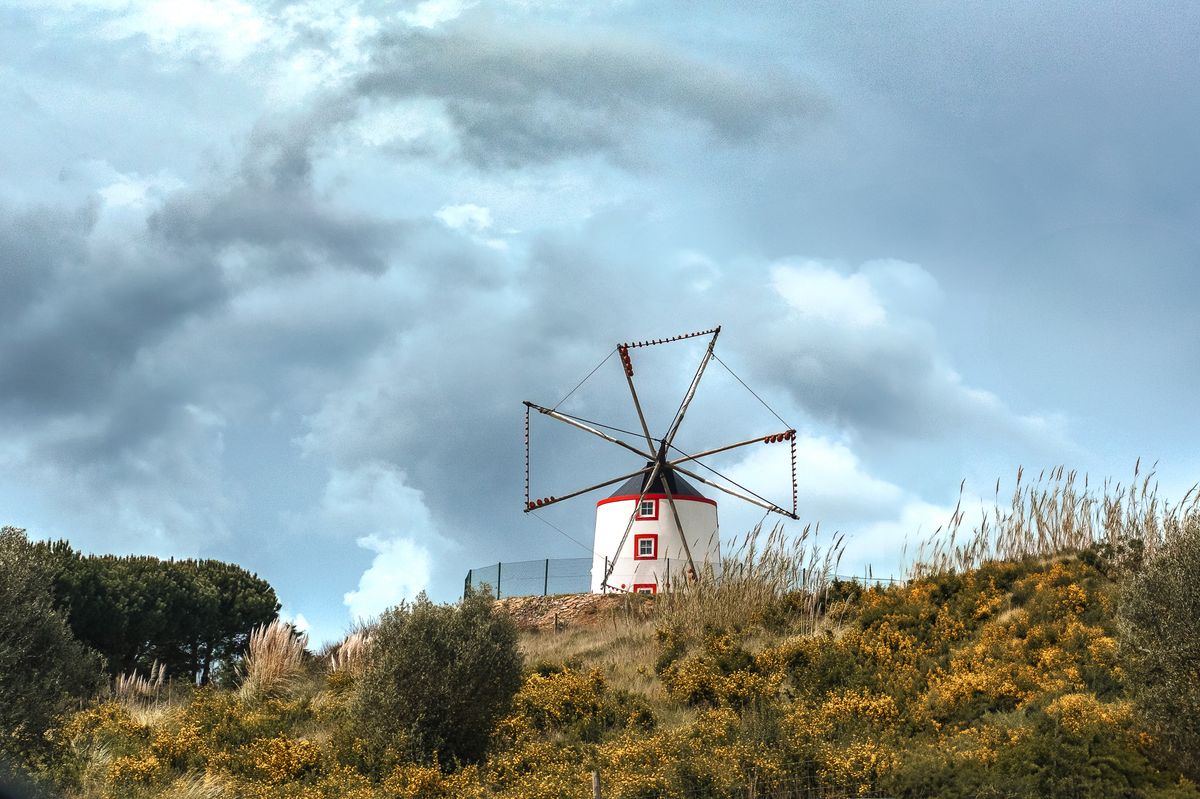 Moara de vant alba pe deal, sub nori dramatici