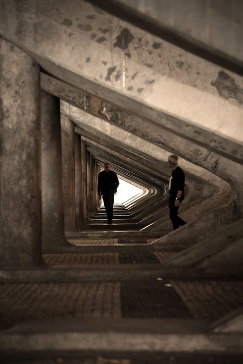 Free A striking urban tunnel with geometric angles featuring two silhouetted figures. Stock Photo