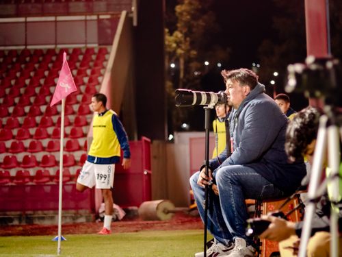 Free Soccer coach intensely watches game at night stadium, focused on strategy. Stock Photo