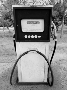 A classic black and white gas pump captured outdoors, exuding vintage charm.