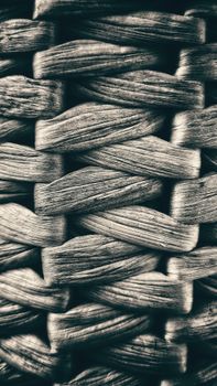 Detailed black and white close-up of a natural woven basket texture, showcasing intricate patterns.