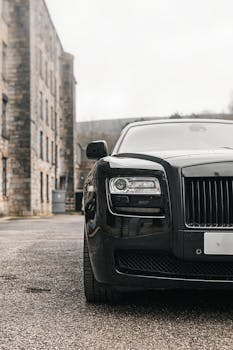 Close-up of a luxury black car parked on an urban street in Manchester, England.