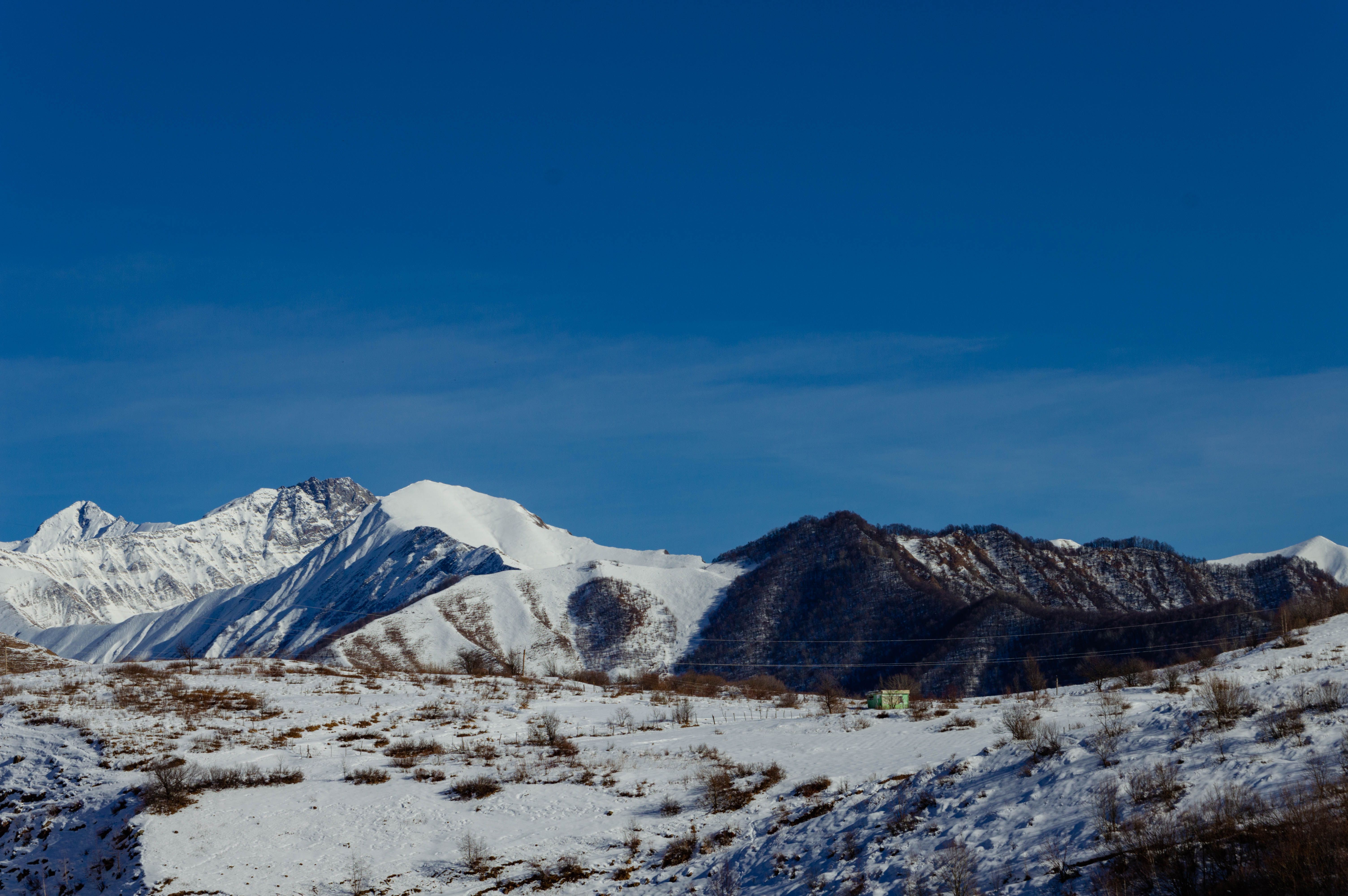 Snow-Covered Mountain Range under Clear Blue Sky · Free Stock Photo