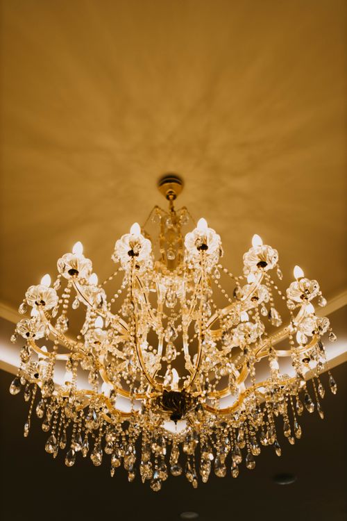 Free Luxurious crystal chandelier illuminating an elegant room, creating a warm and inviting atmosphere. Stock Photo