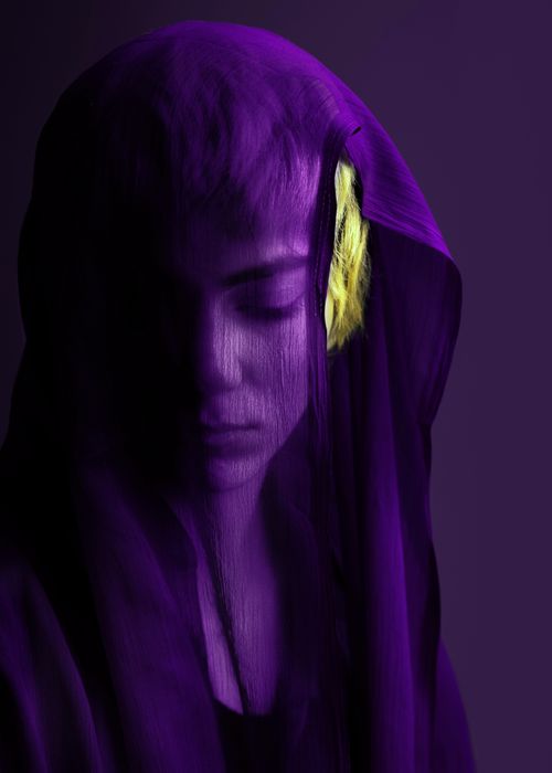 Free Artistic portrait of a woman enveloped in a vibrant purple veil, highlighting serene beauty. Stock Photo