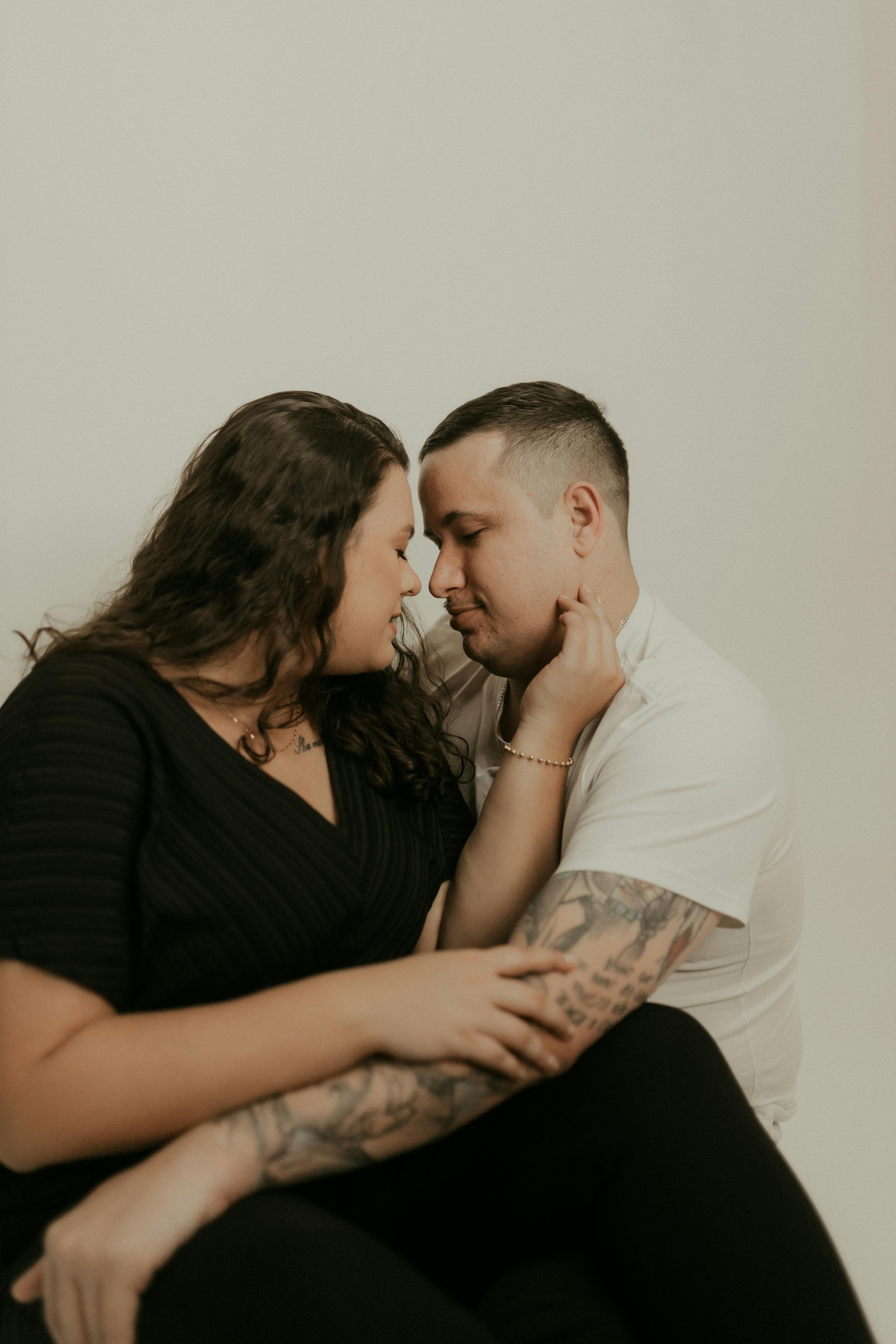 Intimate couple embrace in soft warm light, bodies close in tender connection and trust