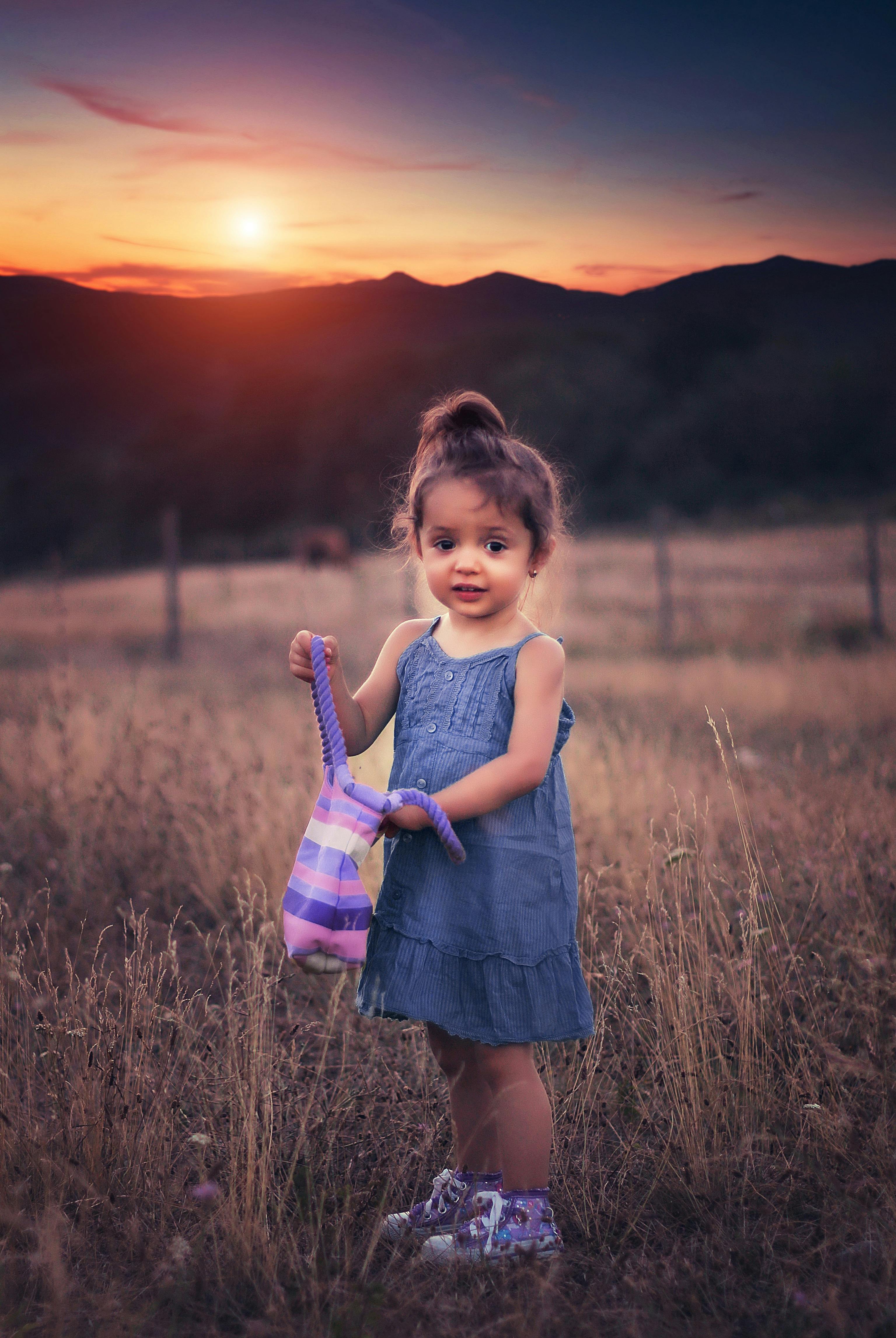 Closeup portrait of cute baby girl posing in winter clothes outdoors.  Stylish child. Looking at camera. Childhood. Stock Photo