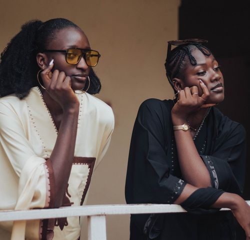 Free Two stylish African women enjoying a relaxed moment outdoors, exuding elegance and confidence. Stock Photo