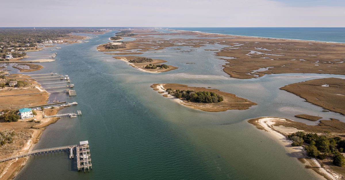 Aerial capture of serene waterway and marshlands near Wrightsville Beach, NC.