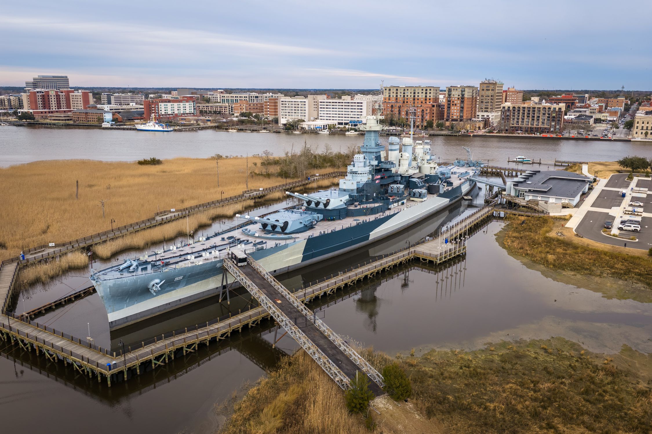 Aerial view of the USS North Carolina in Wilmington, NC with cityscape.