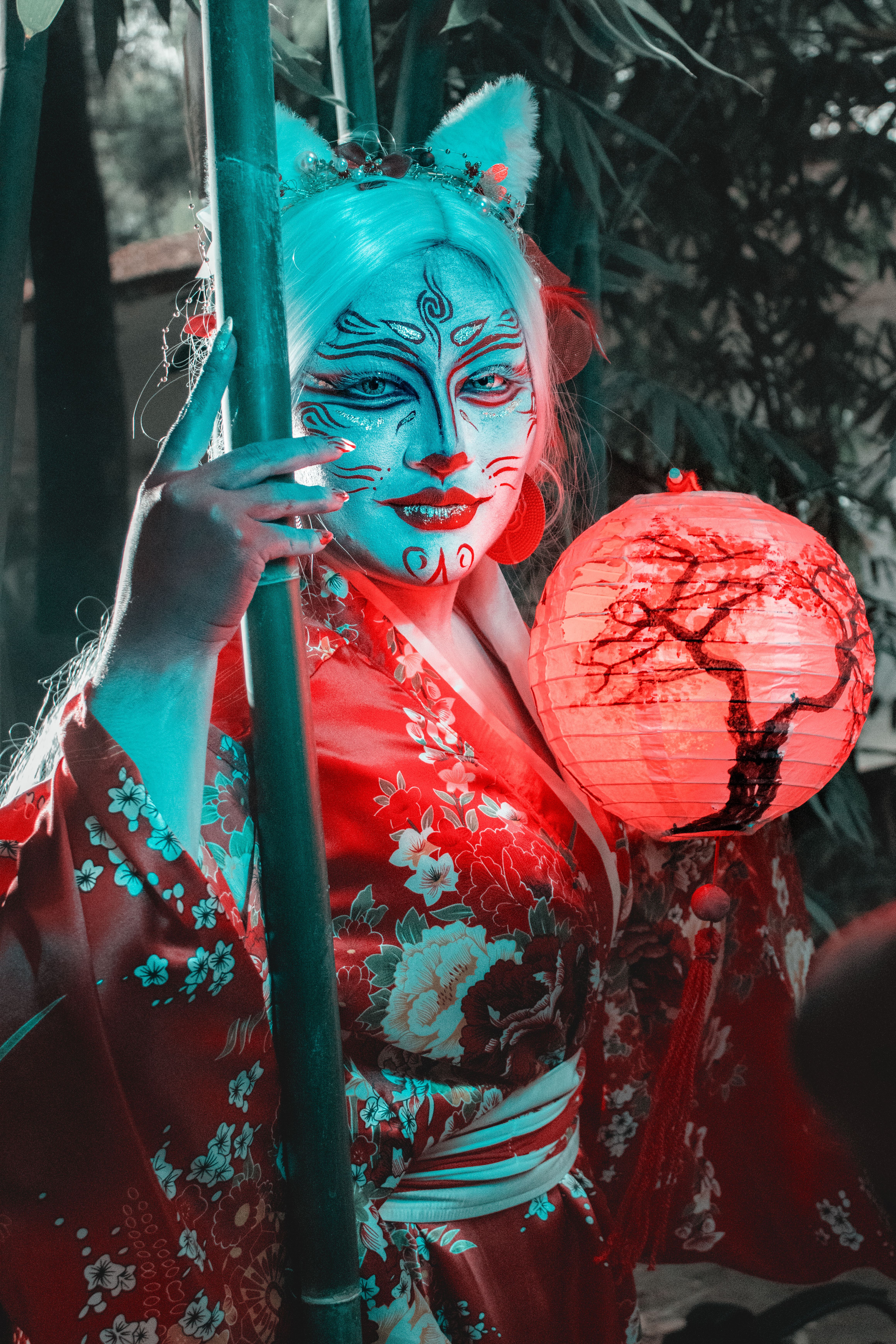 Vibrant cosplay featuring a person in a Japanese kimono with a glowing red lantern outdoors.