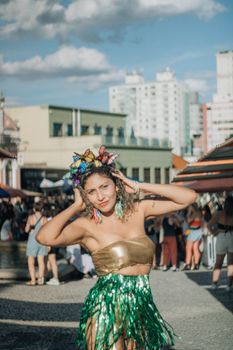 Woman in festive costume enjoying a lively outdoor carnival scene.
