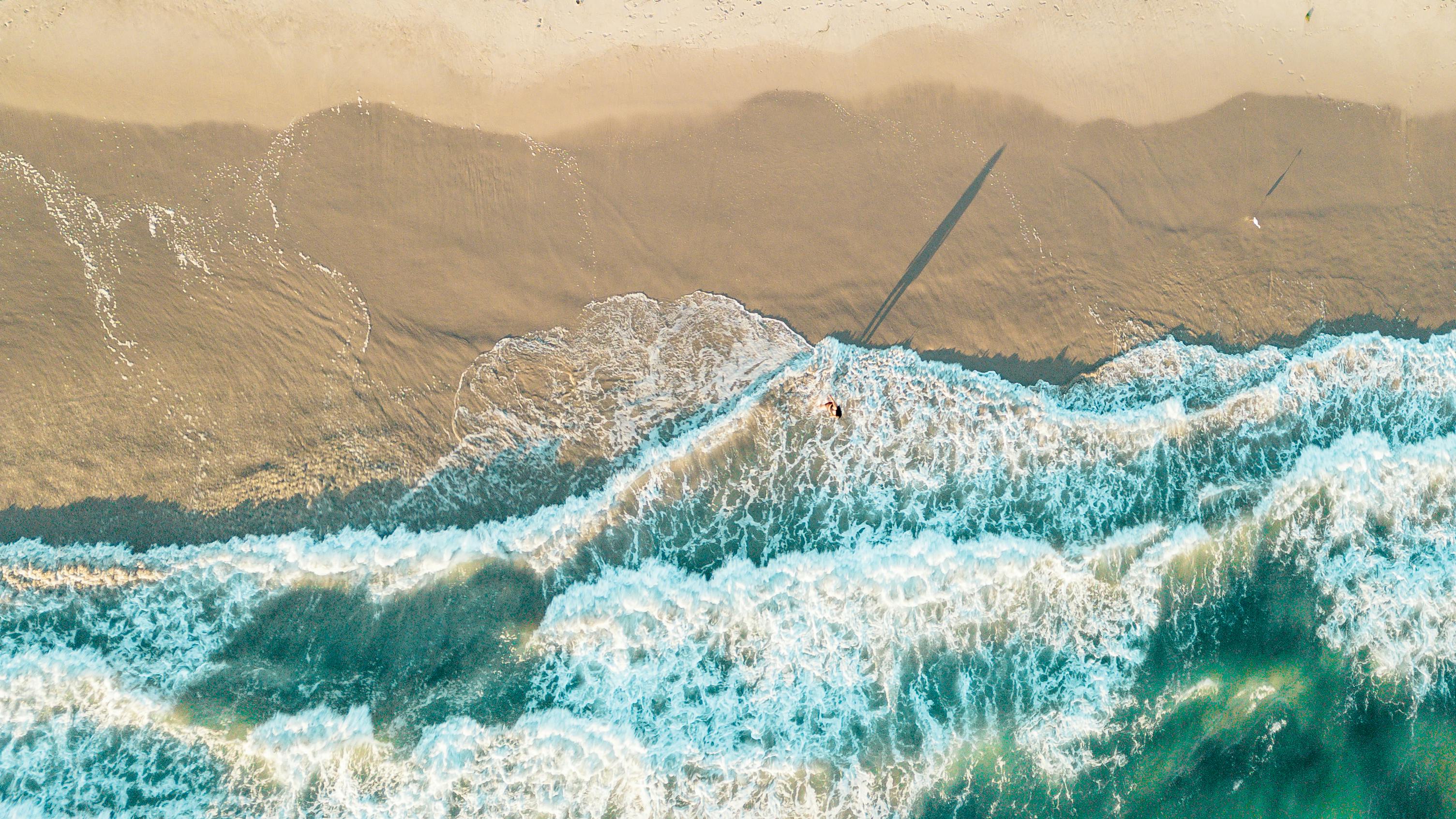 無料 カリフォルニア州マリブビーチの海岸に打ち寄せる波の素晴らしい空中写真。 写真素材