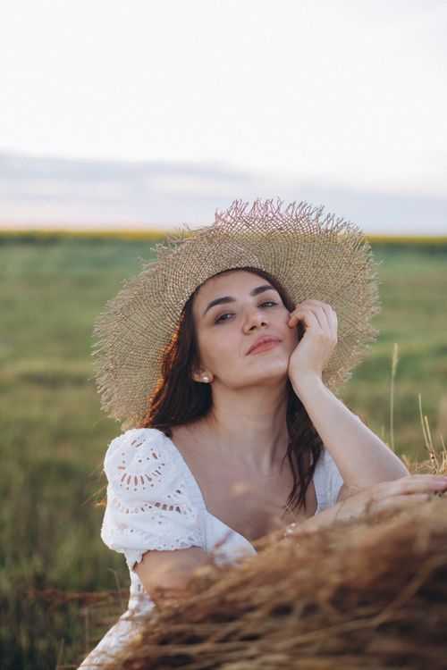 Woman in straw hat in sunny meadow portrait · Free Stock Photo