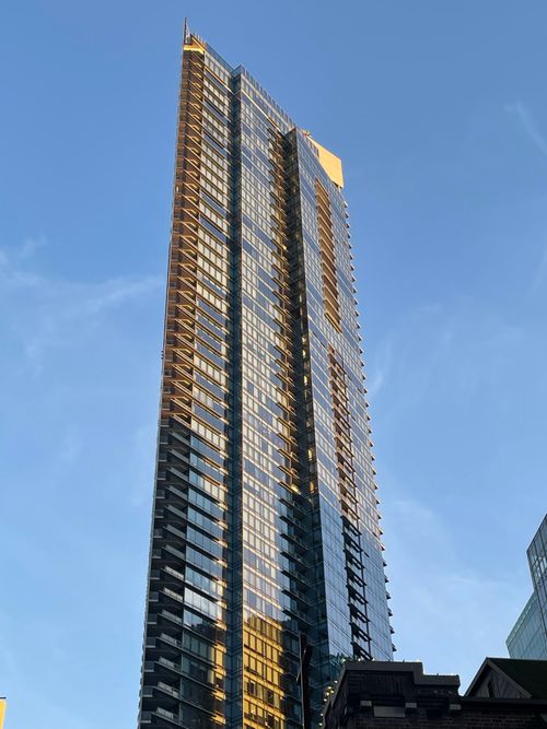 Free Stunning skyscraper reflecting sunlight against a clear blue sky. Stock Photo