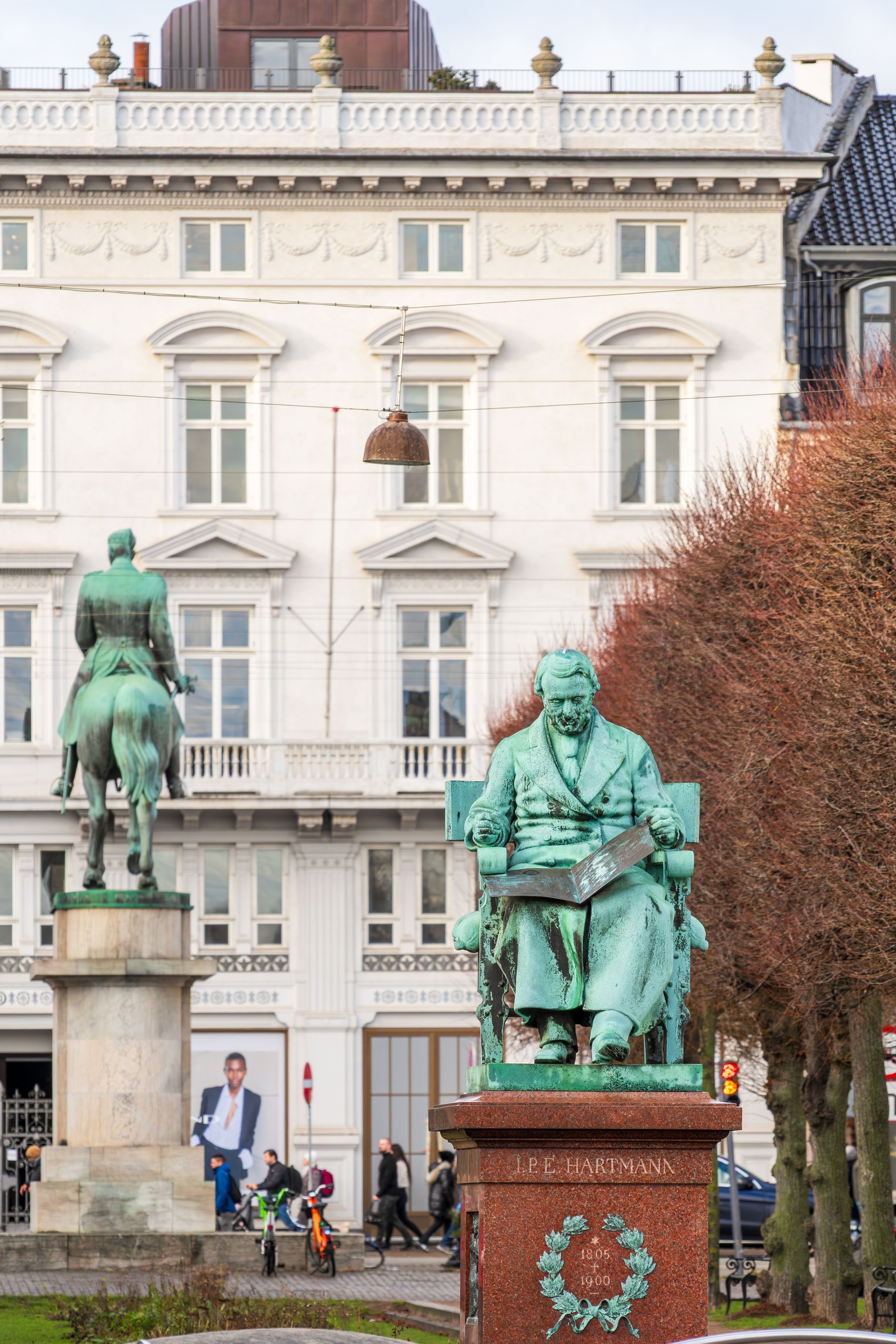 Bronze statues of historic figures in a vibrant Copenhagen square, perfect for travel and architecture enthusiasts.