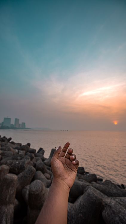 Person Reaching Their Arm Forward on the Background of the Beach at ...